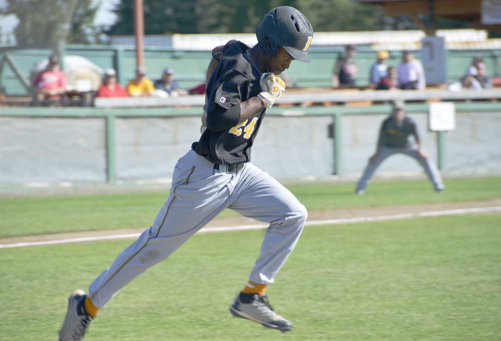 hustles into first base  during a game against the Anchorage Bucaneers on Thursday, July 23. Alas, first baseman  has caught the ball, and  is out.