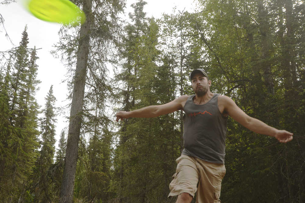 Ben Boettger/Peninsula Clarion Kyle McCowan hurls a frisbee during a disc golf tournament at Tsalteshi Trails on Saturday, July 25.