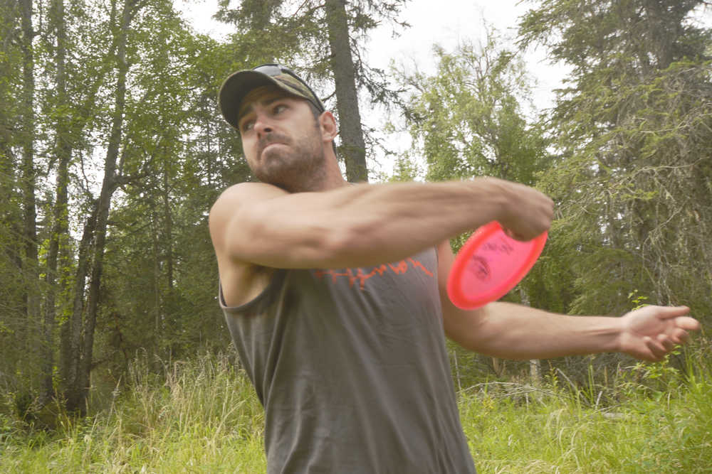 Ben Boettger/Peninsula Clarion Kyle McCowan leans into a throw during a disc golf tournament at Tsalteshi Trails on Saturday, July 25.