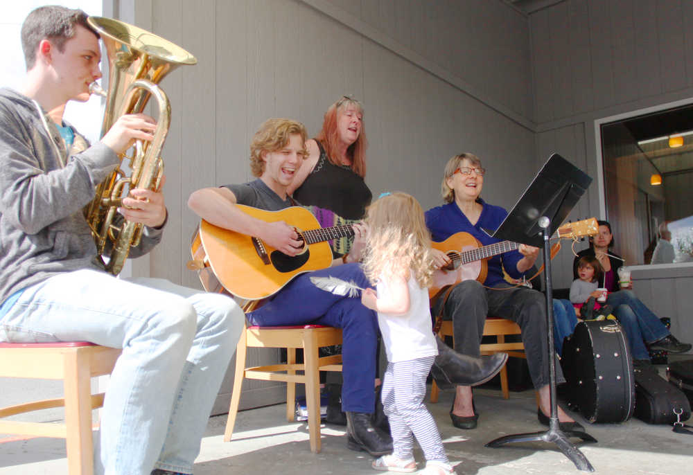 Photo by Kelly Sullivan/ Peninsula Clarion Petra Mayer approaches her father Garrett Mayer during his performance during the Kenai Peninsula Orchestra's Summer Music Festival Monday, July 27, 2015, in Soldotna, Alaska. Players shifted throughout the performance due to a miscommunication. The main musicians including Mayer, Jack Will, Sue Biggs and Logan Boyle, dubbed themselves the Professors Blackstone's Impromptu Wizards. "They just were thrown together last minute, and listen- they are amazing," said music festival's Artisit Director Tammy Vollom-Matturno.