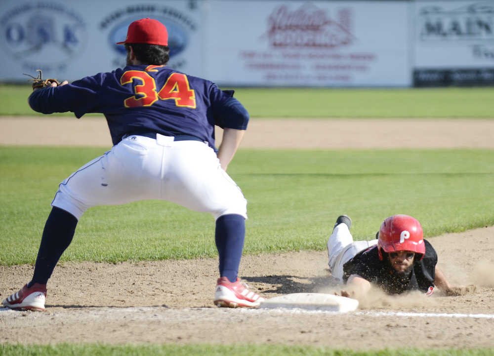 Photo by Kelly Sullivan/ Peninsula Clarion Kenai Peninsula Oilers Brian Ruhm slides back into first base Thursday, July 30, 2015, at Coral Seymour Park in Kenai, Alaska.