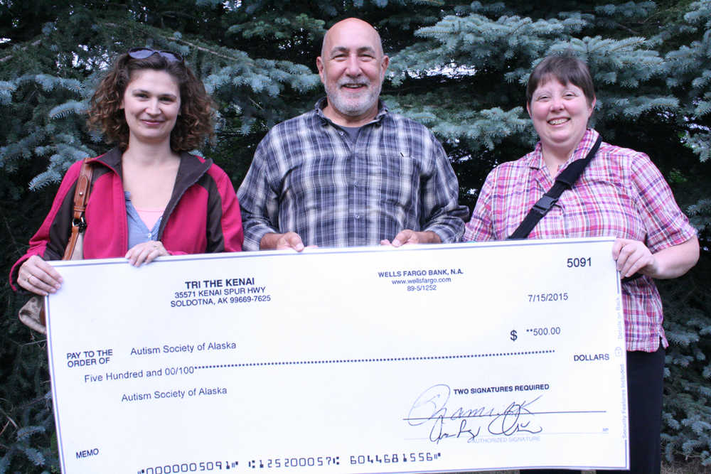 Tanya Updike, left, and Jerri Braun, right, local members and organizers of the Autism Society of Alaska, receive a donation from the Tri The Kenai Triathlon, presented by race director Tony Oliver, center. The Autism Society was the charity focus of this year's triathlon. (Submitted photo)