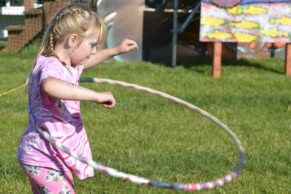 Photo by Megan Pacer/Peninsula Clarion Hayley Herman, 7, plays with a hoola hoop in front of Salmonfest's main stage on Friday July 31, 2015 in Ninilchik, Alaska.