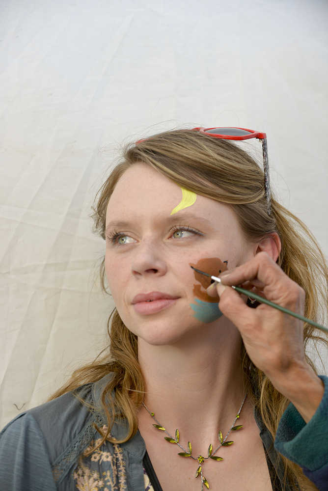 Photo by Megan Pacer/Peninsula Clarion Julia Zagaya, of Tennessee, holds still while her face is painted during Salmonfest on Friday July 31, 2015 in Ninilchik, Alaska.