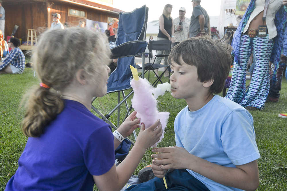 Photo by Megan Pacer/Peninsula Clarion Reece Solomon, 7, enjoys some cotton candy with his sister, 6-year old Hattie Solomon, on the lawn in front of Salmonfest's main stage on Friday July 31, 2015 in Ninilchik, Alaska.