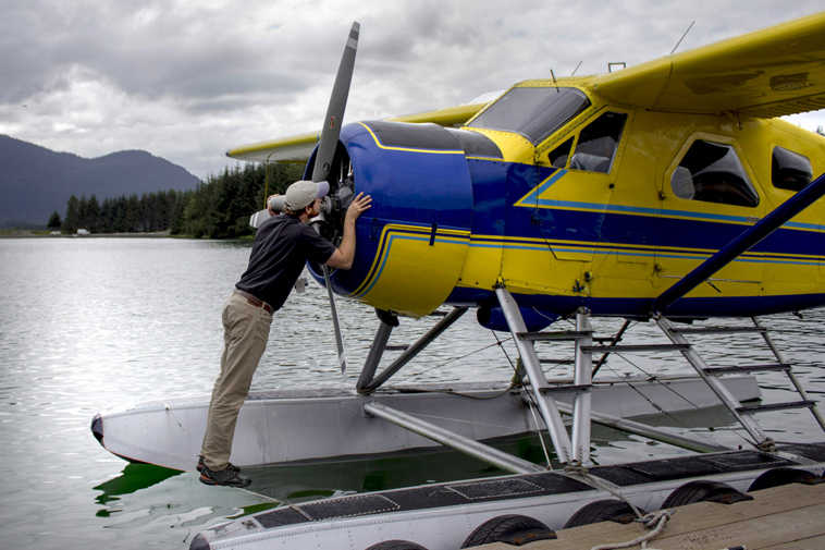 In this Wednesday, July 22, 2015 photo, Sean Kveum does a preflight check on a hydroplane in Juneau, Alaska. The homegrown pilot is now the safety director at Alaska Seaplanes where he has a hand in training new pilots and developing emergency response plans. With more than 250 villages statewide lacking road systems, it's the daily trips to the grocery store and doctor visits that keep Kveum busy. (Michael Penn/Juneau Empire via AP)
