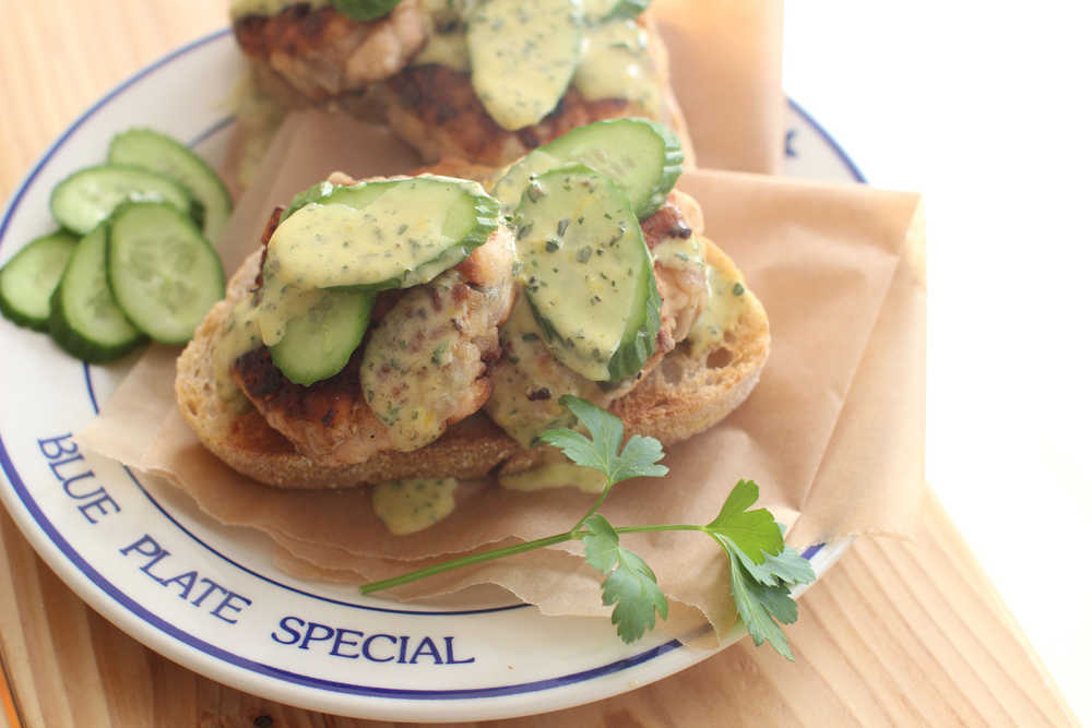 This March 16, 2015 photo shows pink salmon cakes on sourdough with lemon herb aioli  in Concord, NH. (AP Photo/Matthew Mead)