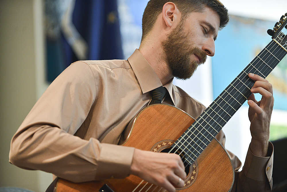 Photo by Rashah McChesney/Peninsula Clarion  Armin Abdihodzic, a classical guitarist, plays on Wednesday August 5, 2015 at the Kenai Chamber of Commerce and Visitors Center in Kenai, Alaska. Abdihodzic played during the Noontime Tunes concert series for the Kenai Peninsula Orchestra's Summer Music Festival.