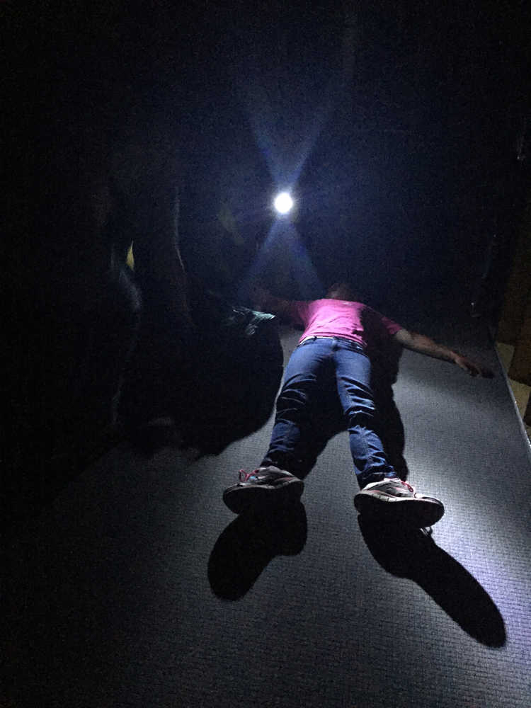 Photo by Megan Pacer/Peninsula Clarion Kellee Martin, 11, pretends to be an injured victim of an earthquake for a Community Emergency Response Team disaster simulation held on Saturday Aug. 8, 2015, at Soldotna Prep School in Soldotna, Alaska.