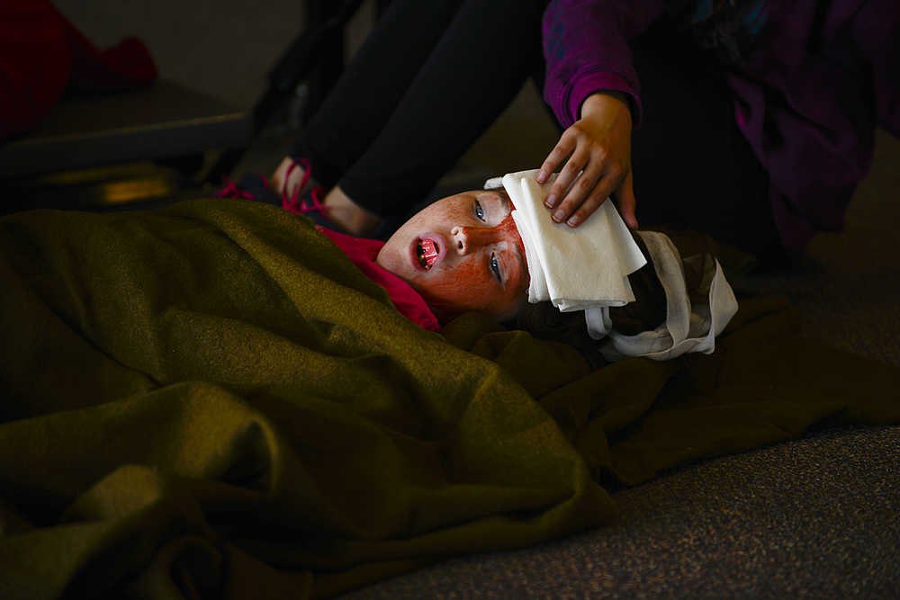 Photo by Rashah McChesney/Peninsula Clarion  Kellee Martin, 11, lays on the floor of the Soldotna Prep lobby feigning injury during a Community Emergency Response Training drill on Saturday August 8, 2015 in Soldotna, Alaska.