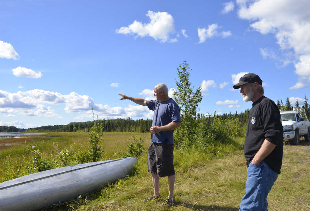 Photo by Megan Pacer/Peninsula Clarion Kenny Merkes (left) and his neighbor Tommy Patterson (right) visit the site of an attempted theft of Merkes' boat motor on Wednesday Aug. 12, 2015 on Moose River in Sterling, Alaska. Two men in a yellow canoe attempted to take the boat motor before abandoning it in the canoe and fleeing into the woods near Moose River.