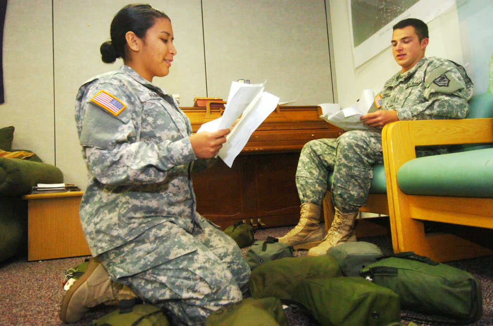 Ben Boettger/Peninsula Clarion Privates Jessica Ramos (left) and Sam Cottrell (right) of the National Guard's 297th Cavalry Brigade inventory kit bags containing night-vision instruments at Kenai's National Guard Armory on Wednesday, August 12. The night-vision equipment is among the gear being redistributed as the cavalry unit becomes infantry.