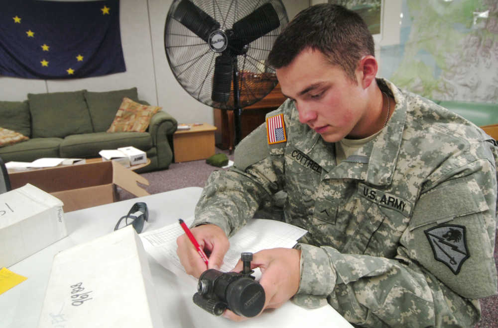 Ben Boettger/Peninsula Clarion Private Sam Cottrell of the National Guard's 297th Cavalry Brigade inventories a rifle scope - equipment that will be redistributed as the cavalry unit becomes infantry - at Kenai's National Guard Armory on Wednesday, August 12.