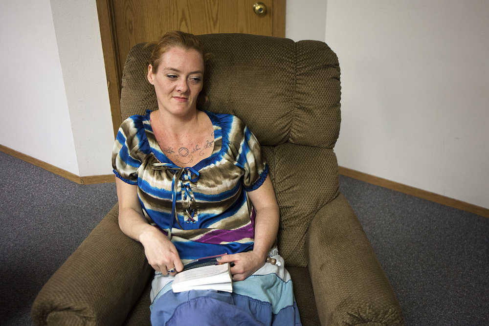 Photo by Rashah McChesney/Peninsula Clarion  Aubrey Austin curls up with a book in an armchair at the LeeShore Center where she has been staying for two months on August 13, 2015 in Kenai, Alaska. The center is in its 30th year of operating. At present, all 32 of its beds are filled.