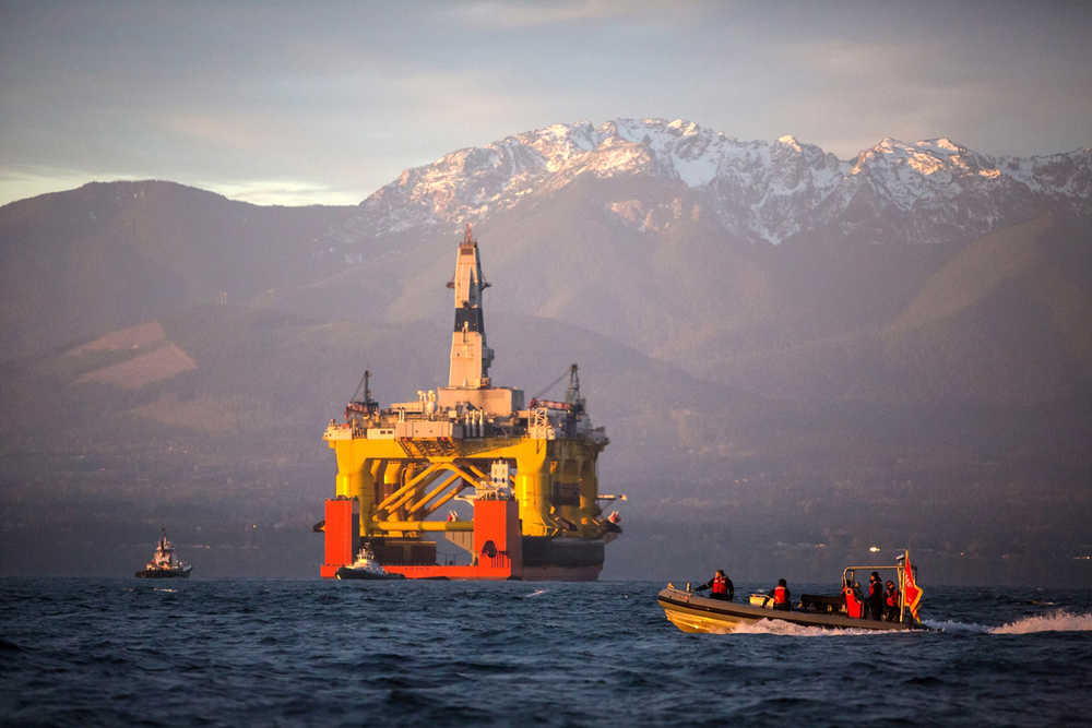 FILE - In this April 17, 2015 file photo, with the Olympic Mountains in the background, a small boat crosses in front of the Transocean Polar Pioneer, a semi-submersible drilling unit that Royal Dutch Shell leases from Transocean Ltd., as it arrives in Port Angeles, Wash., aboard a transport ship after traveling across the Pacific before its eventual Arctic destination. The U.S. government on Monday gave Shell the final permit it needs to drill for oil in the Arctic Ocean off Alaska's northwest coast for the first time in more than two decades.  (Daniella Beccaria/seattlepi.com via AP, File) MAGS OUT; NO SALES; SEATTLE TIMES OUT; TV OUT; MANDATORY CREDIT