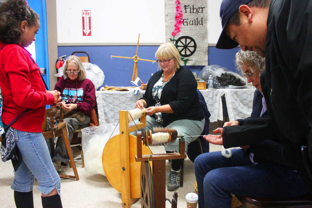 Photo by Kelly Sullivan/ Peninsula Clarion Fireweed Fiber Guild members Lee Choray-Ludden, Martha Merry, Jane Conway answer questions from Telotha Braden and her father Mario Reyna, Friday, August 15, at the Kenai Peninsula Fair in Ninilchik, Alaska.