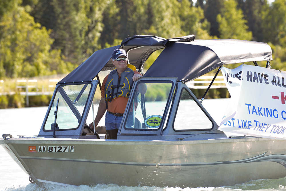Photo by Rashah McChesney/Peninsula Clarion  A protestor pulls his boat away from the Swiftwater Campground before heading to protest in front of a Kenai River Sportfishing Association event at founder Bob Penney's riverfront house on Wednesday August 19, 2015 in Soldotna, Alaska.
