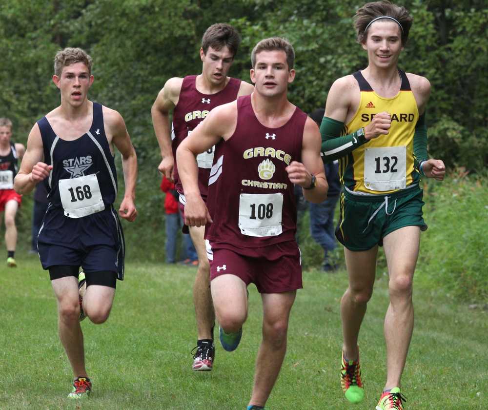 Soldotna's Aaron Swedberg, left, and Seward's Hunter Kratz, right, prepare to pass a pair of Grace Christian runners during the Colony Invitational Aug. 15 at Colony High School in Palmer. Kratz won the boys varsity race.