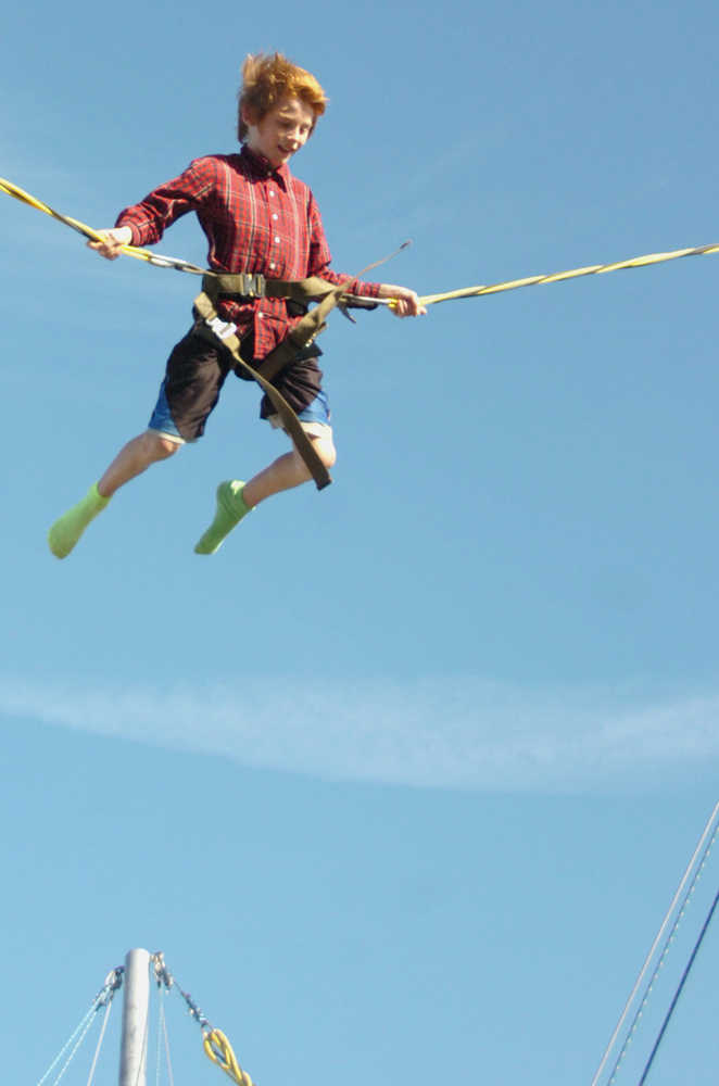 Ben Boettger/Peninsula Clarion Grayden Musgrave reaches the peak of his bounce on a bungee trampoline at the Ninilchik Fair Ground during the Kenai Peninsula State Fair on Friday, August 22.