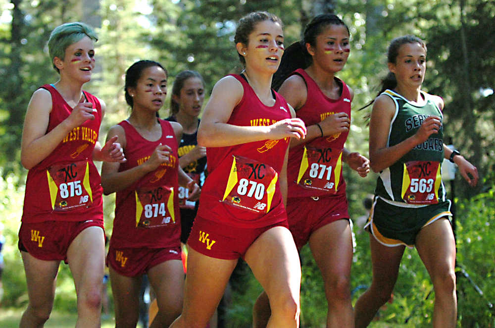 Ben Boettger/Peninsula Clarion Service High School varsity runner Bryn Waite (right) attempts to pass a pack from West Valley High School during the Tsalteshi Invitational Cross Country race at Skyview High School on Saturday, August 22.