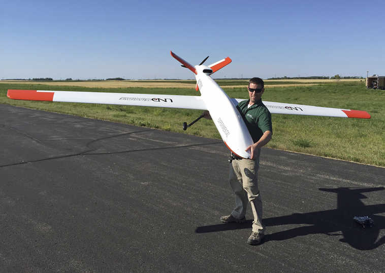 In this Aug. 4, 2015 photo provided by the University of North Dakota, UND pilot Schuyller "Sky" Andrew holds a Draganflyer X4ES drone that he flew on a test flight from the Lakota, N.D., airport that was conducted for the Northern Plains UAS Test Site. The North Dakota site has been granted approval by the Federal Aviation Administration to fly drones about 200 feet and fly them at night. It is the first of six national test sites to fly at night. (Andrew Regenhard/University of North Dakota via AP)