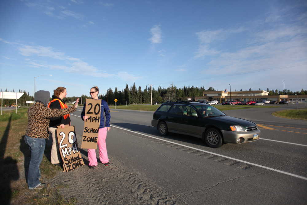Photo by Kelly Sullivan/ Peninsula Clarion (Left) Kelly DeSmidt, Sarah Williams and Sterling Elementary School Principal Denise Kelly hold signs depicting the School Zone's speed limit Friday, Aug. 28, 2015, outside Sterling Elementary in Sterling, Alaska.