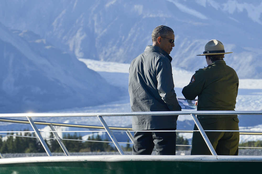 Photo by Rashah McChesney/Peninsula Clarion  Rebekka Federer chases her two-year-old son Finn as he runs along the Seward Highway looking for his bicycle while police officers attempt to move a crowd away from Airport Road where President Barack Obama's motorcade drove to reach Exit Glacier on Tuesday Sept. 1, 2015 in Seward, Alaska.