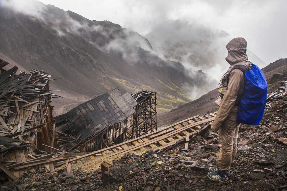 ADVANCE FOR WEEKEND OF AUG. 29-30, 2015. In this August 9, 2015 photo, Christine Simko stands above Bonanza Mine on a rainy day in the Kennecott Mines National Historic Landmark on the Wrangell-St. Elias National Park and Preserve near McCarthy, Alaska. Depending on who you ask, the 9-mile round trip from Kennecott Mill Town to Bonanza Mine is either "an easy one" or "unrelenting." Similar sentiments could be applied to the nearby Jumbo Mine trip, which is one mile longer and rises 3,400 feet. (Robin Wood/Fairbanks Daily News-Miner via AP)