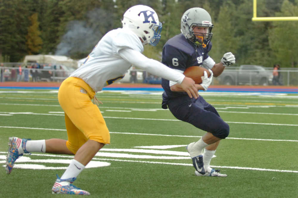 Ben Boettger/Peninsula Clarion Kodiak High School football player Giovanni Martinez (left) attempts to tackle Soldotna player Jesse Littrell during a game on Saturday Sept. 5 at Soldotna High School.