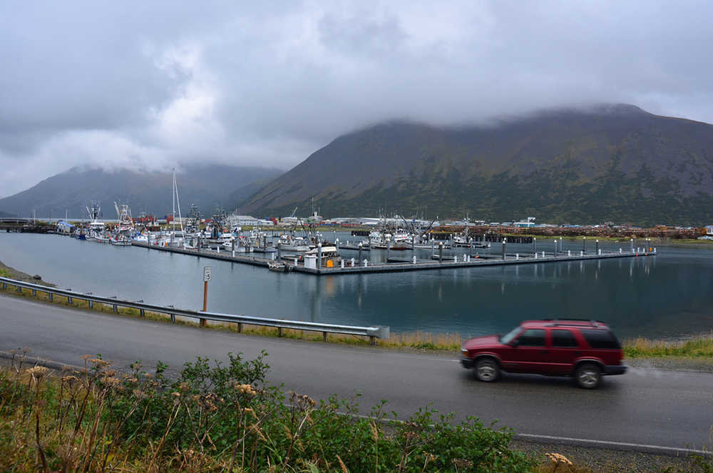 In this photo taken Sept. 23, 2013, a driver passes the small boat harbor in King Cove, Alaska.  A federal judge in Alaska on Tuesday, Sept. 8, 2015, dismissed a lawsuit brought over the U.S. Interior Department's refusal to allow for a road from King Cove to an all-weather airport at Cold Bay. The road has drawn opposition from environmental groups because it would run through Izembek National Wildlife Refuge.  (James Brooks(/Kodiak Daily Mirror via AP) MANDATORY CREDIT