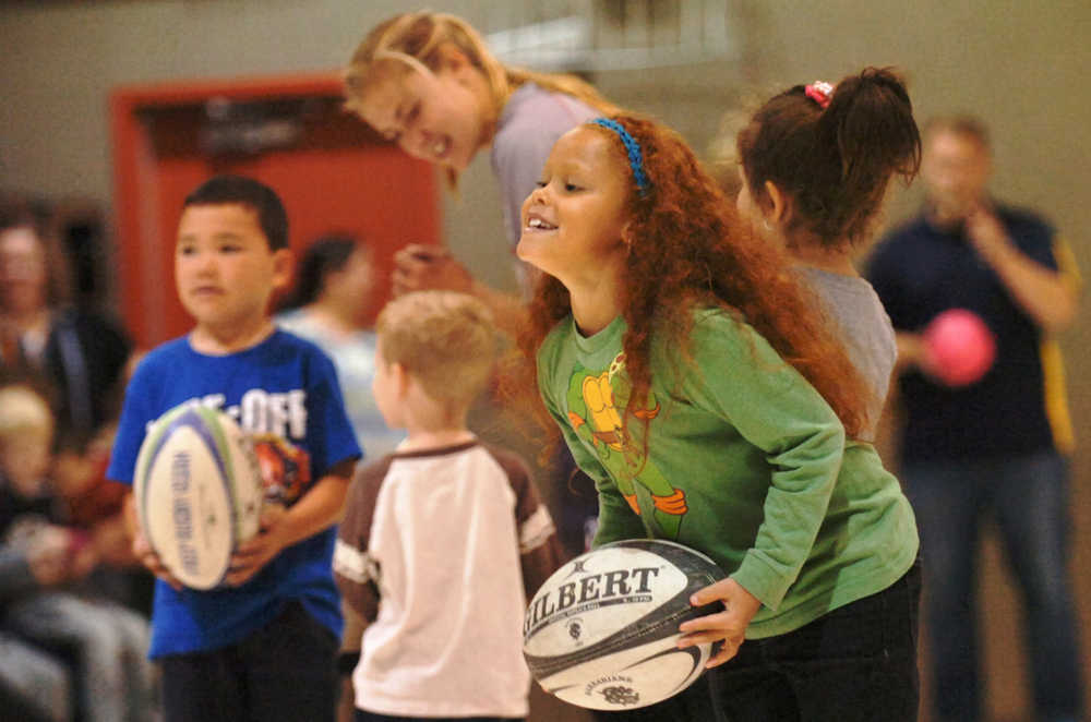 Ben Boettger/Peninsula Clarion Students hold rugby balls as members of the U.S Women's Rugby Sevens Olympic team prepare to lead them in a tag-like game during a presentation on Wednesday, September 9 in the gymnasium of Mountain View Elementary School.