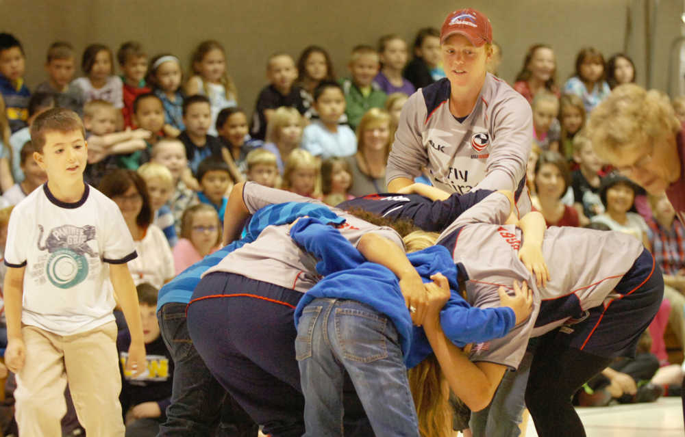 Ben Boettger/Peninsula Clarion U.S Olympic Women's Sevens Rugby player Alev Kelter (in red cap) directs a scrum made of Mountain View Elementary students and her team mates Amy Naber and Meya Bizer during a presentation on Wednesday, September 9 at Mountain View Elementary School.
