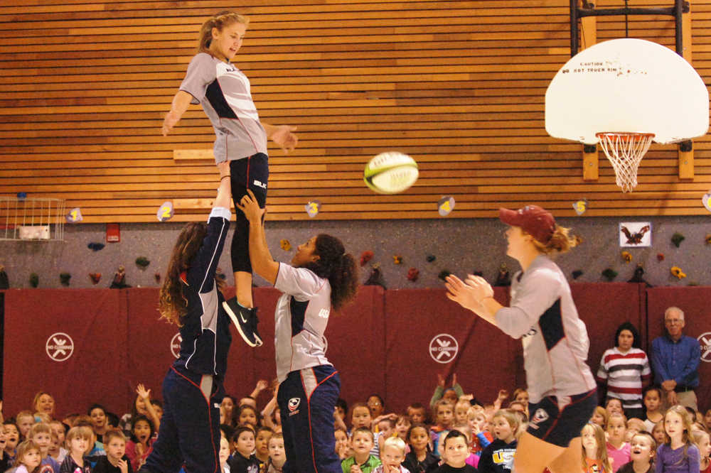 Ben Boettger/Peninsula Clarion Hoisted by her team mates Meya Bizer (left) and Amy Naber, U.S Olympic Rugby Sevens player Richelle Stephen returns a line-out pass to Alev Kelter during a presentation to students on Wednesday, September 9 at Mountain View Elementary School in Kenai.