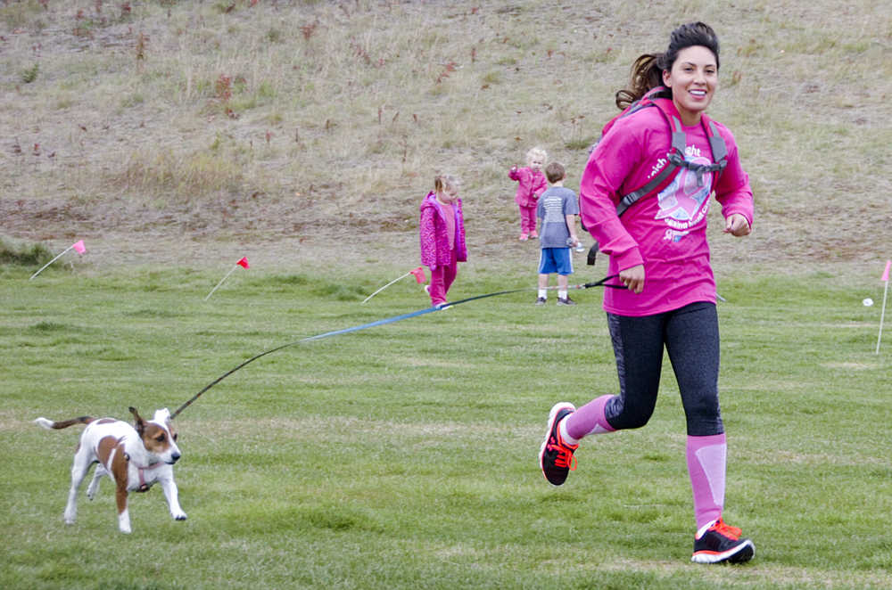Photo by Megan Pacer/Peninsula Clarion A runner and her dog cross the finish line at the Making Strides Against Breast Cancer Walk/Run on Sunday, Sept. 13, 2015 at the Tsalteshi Trails in Soldotna, Alaska.
