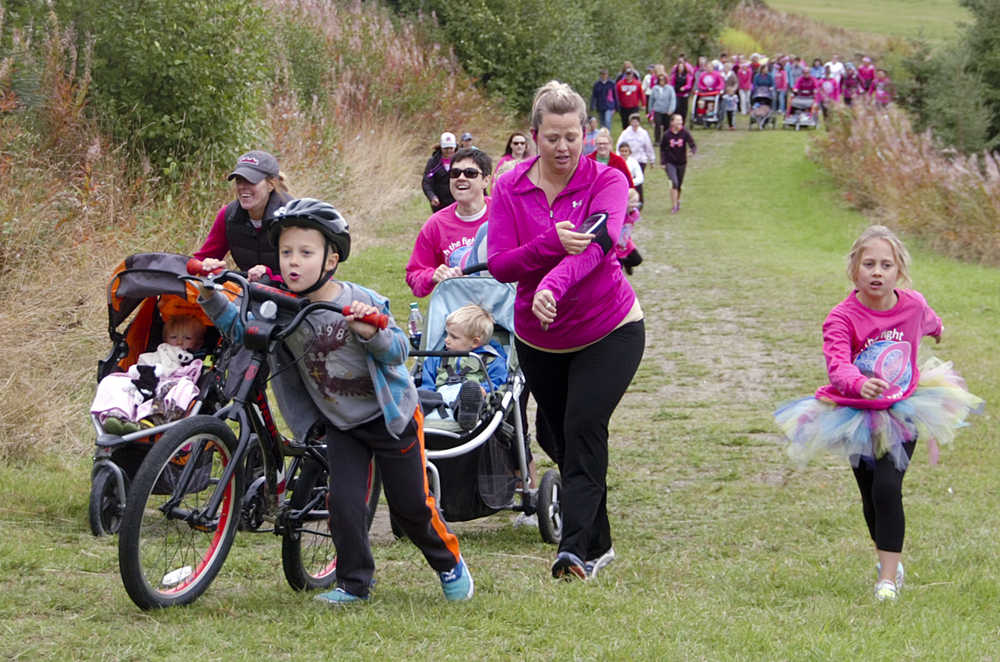 Photo by Megan Pacer/Peninsula Clarion Runners, walkers, parents and children charge up the first hill at the start of the Making Strides Against Breast Cancer Walk/Run on Sunday, Sept. 13, 2015 at the Tsalteshi Trails in Soldtona, Alaska.