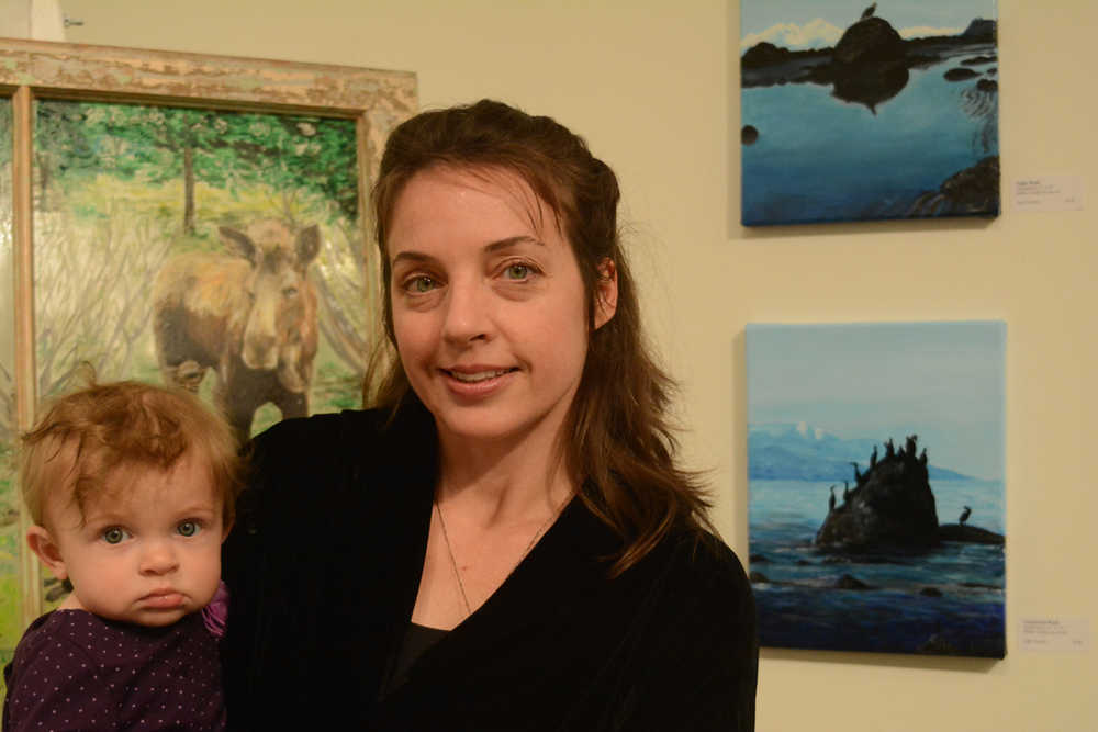 Julie Tomich holds her daughter, Xelia, at her show's First Friday opening. (Photo by Michael Armstrong/Homer News)