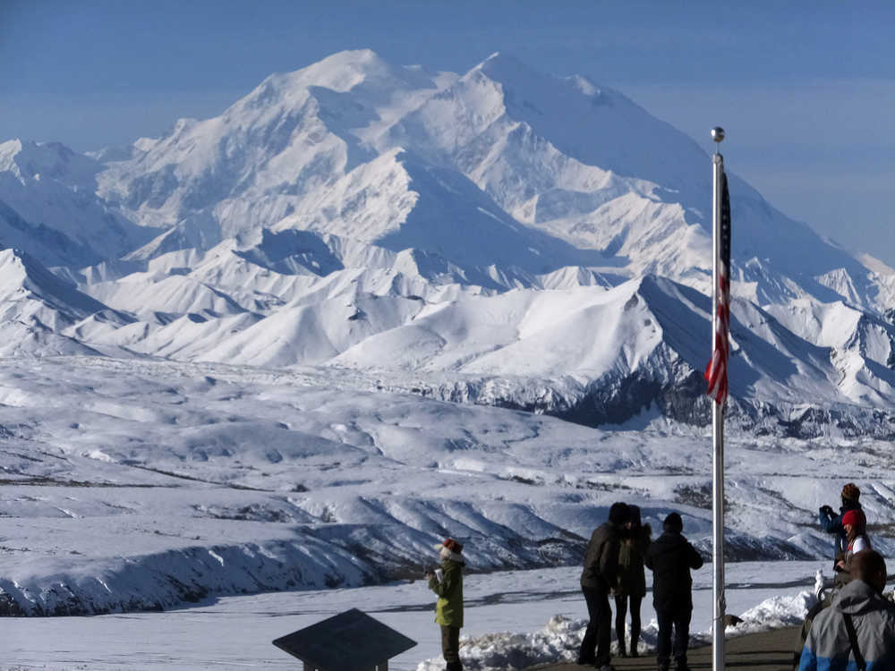 People stand at the Eielson Visitor Center with a view of North America's tallest peak, Denali, in the background, Wednesday, Sept. 2, 2015, in Denali National Park and Preserve, Alaska. The park covers more than 6 million acres, about the size of Vermont, and is an adventurer's paradise with few marked trails, inviting backcountry exploration. (AP Photo/Becky Bohrer)