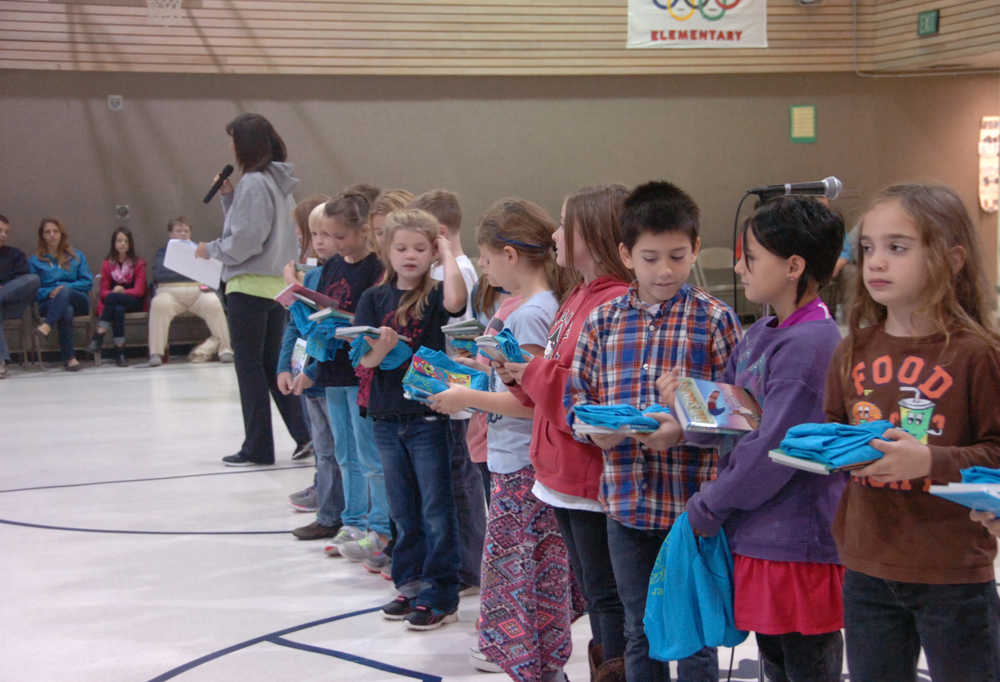 Photo by Megan Pacer/Peninsula Clarion Students who kept a log of what the read over the summer recieve books, a t-shirt and other prizes on Friday, Sept. 18, 2015 during a RIGS assembly at Kalifornski Beach Elementary in Soldotna, Alaska.