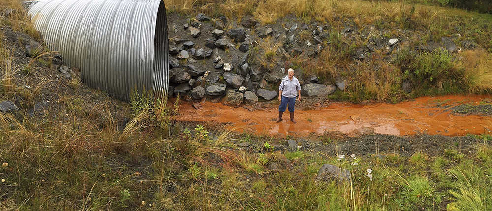 Photo by Rashah McChesney/Peninsula Clarion  Kenai Peninsula Borough resident Dan Sterchi stands in a drainage ditch that was built near a portion of Kalifornsky Beach Road that has collapsed and washed into the Cook Inlet twice on Sept. 4, 2015 near Kenai, Alaska. Sterchi's nearby home borders a parcel that the borough is considering trading to a private property owner minus an easement which he says will not be large enough to allow for adequate drainage of floodwater in the area.