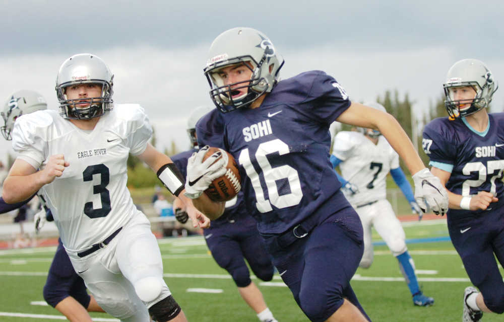 Ben Boettger/Peninsula Clarion Soldotna Varsity football player Tommy Flores runs with the ball with Eagle River's George Hunter in pursuit during a game on Saturday, September 19 at Soldotna High School.