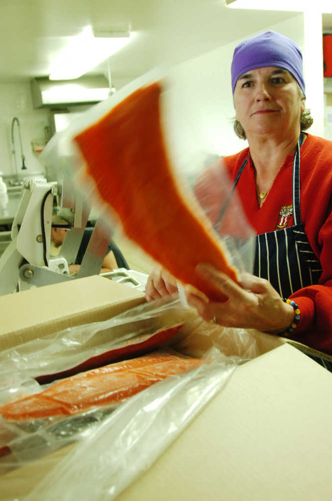 Ben Boettger/Peninsula Clarion Kenai Senior Center cook Melissa "Missy" Bailey examines a frozen, vacuum-packed sockeye fillet donated to the Senior Center by the Alaska Salmon Alliance on Wednesday, Sept. 23 in the kitchen of the Kenai Senior Center.