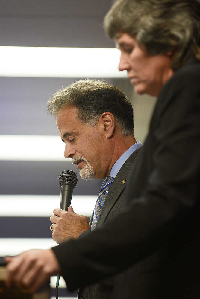 Photo by Rashah McChesney/Peninsula Clarion  Sen. Peter Micciche, R-Soldotna, reads through a budget presentation with Alaska's budget director Pat Pitney during a joint chamber luncheon event on Wednesday Sept. 23, 2015 in Soldotna, Alaska.