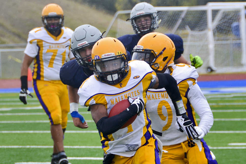 Photo by Rashah McChesney/Peninsula Clarion  Lathrop's Ricardo Henry takes off with the ball during a game against Soldotna on Saturday Sept. 26, 2015 in Soldotna, Alaska.