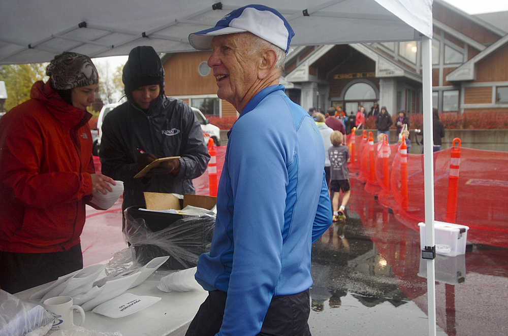 Photo by Megan Pacer/Peninsula Clarion Soldotna resident Roy Stuckey, 72, waits for his medal after finishing the half marathon on Sunday, Sept. 27, 2015 during the annual Kenai River Marathon at the Kenai Chamber of Commerce and Visitor Center in Kenai, Alaska.