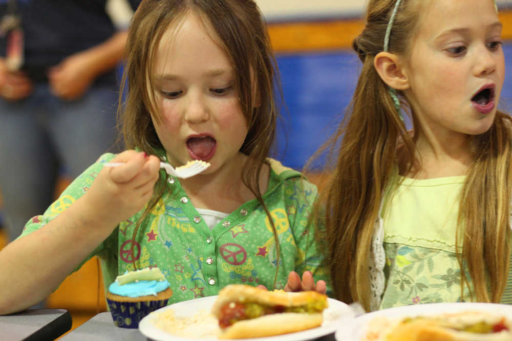 Photo by Kelly Sullivan/ Peninsula Clarion Second grader Emma McKay enjoys a plate of cheesy potatoes during Soldotna' Montessori's annual Peace Day Harvest potluck Monday, Sept. 21, 2015, at Soldotna Elementary in Soldotna, Alaska.