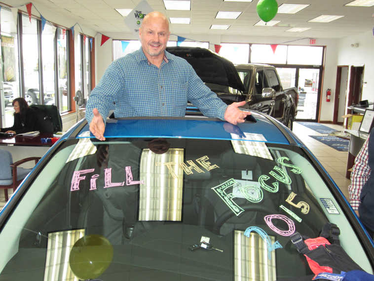 Stanley Ford sales manager Joe Wink displays some of the donations collected during the dealership's Fill the Focus Event.