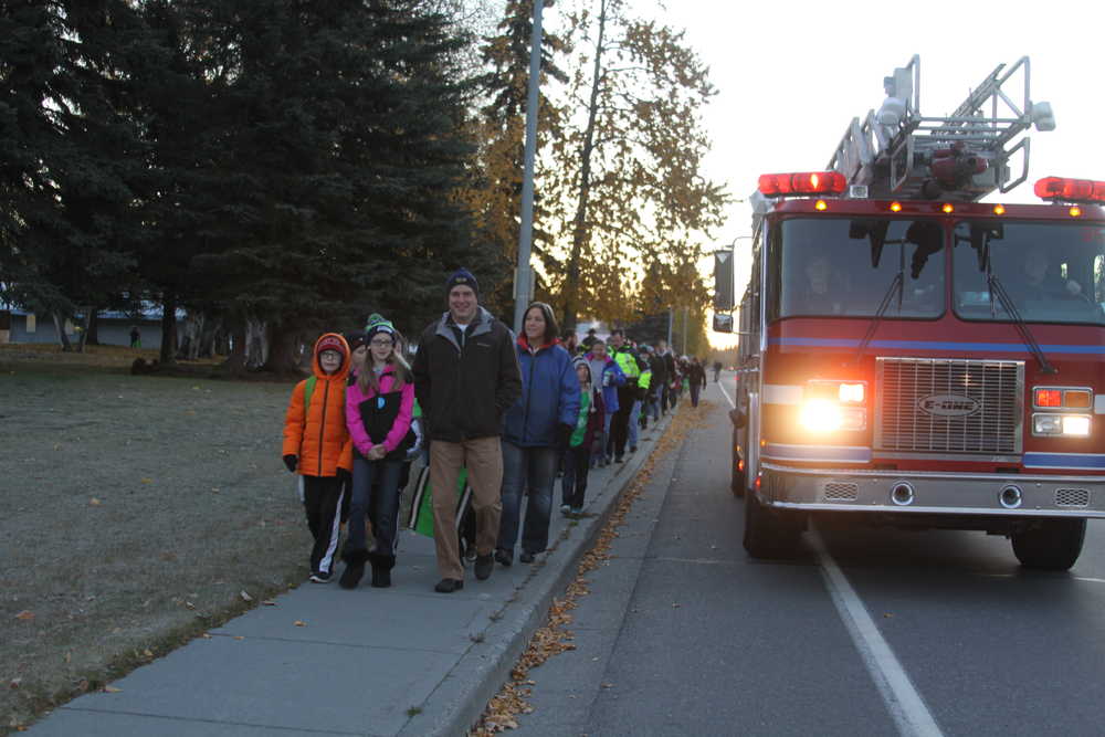 A Central Emergency Services ladder truck leads the way to school on Walk to School Day.