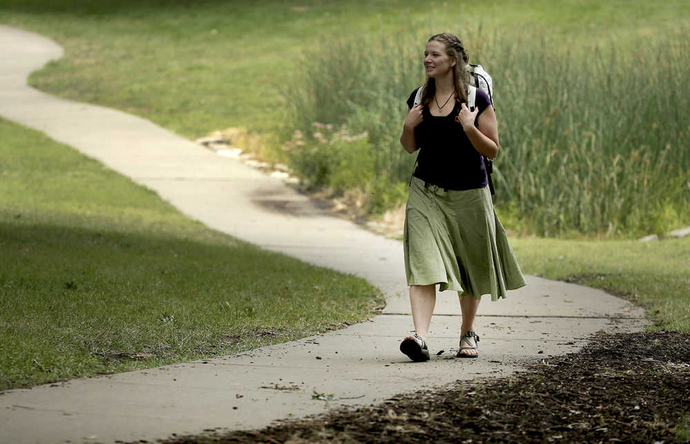 In this photo taken Aug. 28, 2015, Bethany Hughes walks through a park in Kansas City, Mo. as she prepares for her upcoming hike through the Americas. Hughes hopes to become the first woman to trek from the southern tip of South America to the northern tip of Alaska all by non-motorized means. (AP Photo/Charlie Riedel)