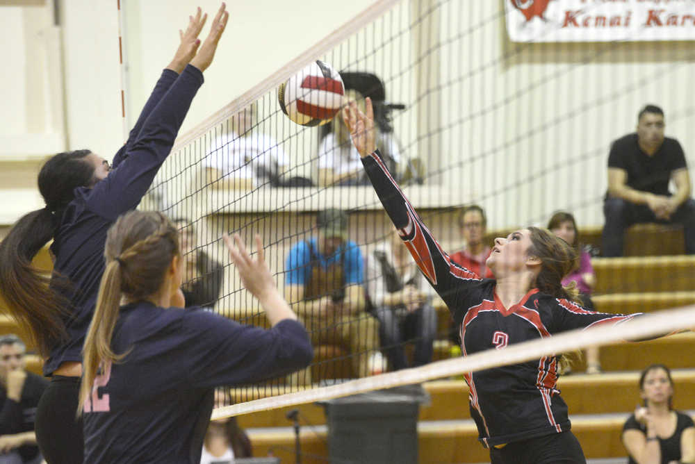 Ben Boettger/Peninsula Clarion Kenai's Alexis Baker gets ball over the net, with Soldotna's Drew Zeek and Sylvia Tuisaula blocking during a game  on Friday, Oct. 9 at Kenai Central High School.