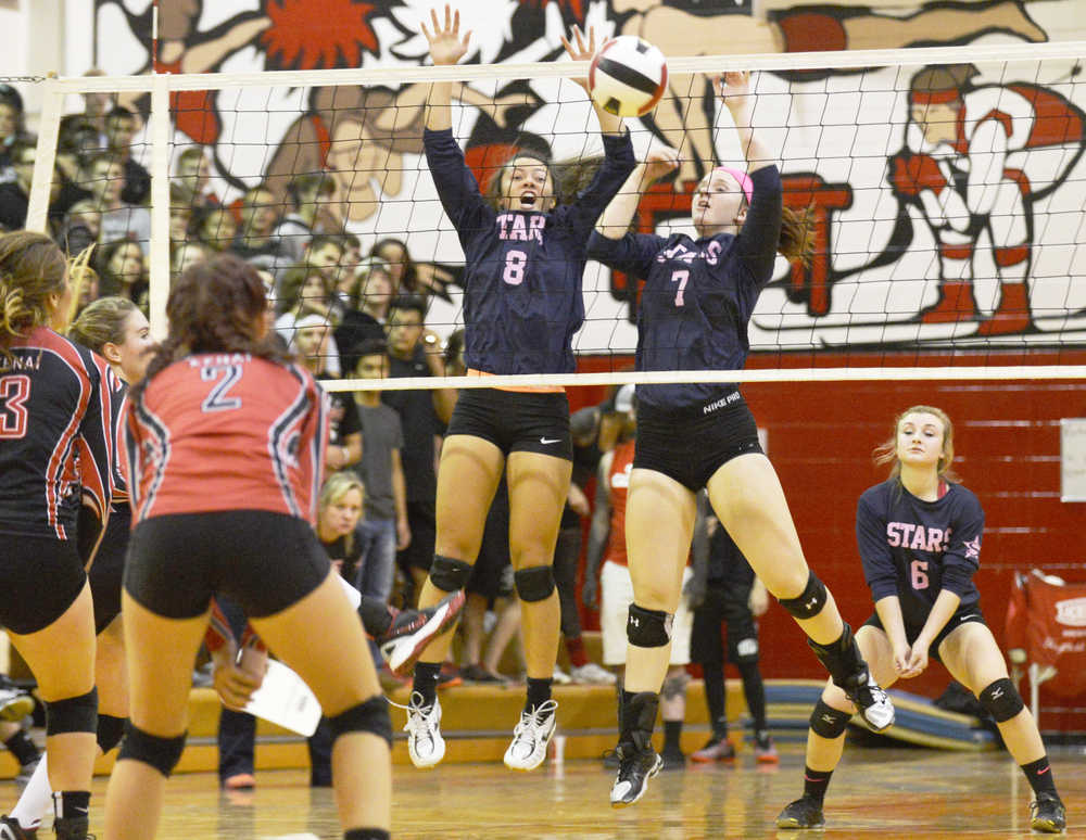 Ben Boettger/Peninsula Clarion Soldotna volleyball players (left) and  hit the ball over the net during a game against Kenai Central High School on Friday, Oct.9 in Kenai.